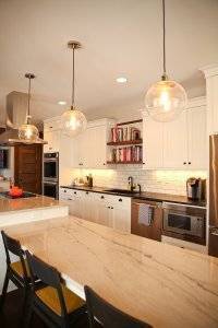 A section of a new kitchen with marble white countertops.