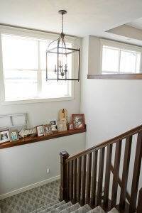 A stairway leading to a lower level with a ledge for pictures.