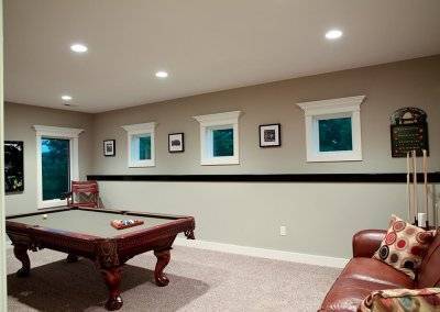 A pool table placed in a basement game room.