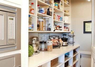 Open shelving with bins and different grocery items placed on the shelves.