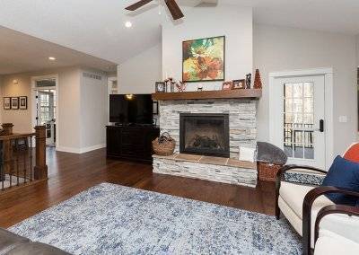 A living room with a fireplace, TV, and a speckled blue rug.