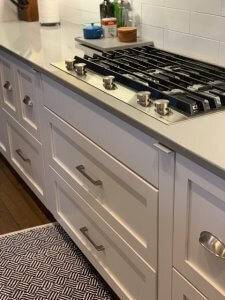 Secret, narrow spice cabinets are concealed on both sides of a stovetop.