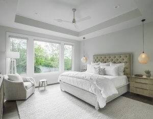 Master bedroom with white duvet, pendant lighting