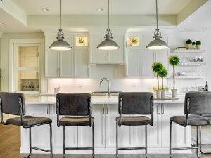 Kitchen island with seating, pendant lighting, custom cabinetry.