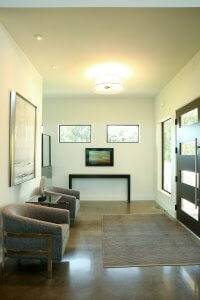 Entry with polished concrete floors, glass paneled door and seating area.