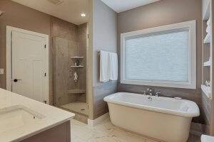 Soaking tub with built in shelving in master bath. Tiled shower and tile floor.