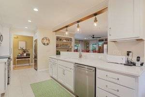 Small white remodeled kitchen with pendant lighting.