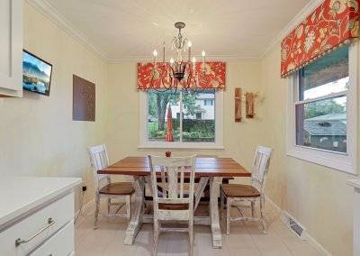 Small eat in kitchen with red window treatments.