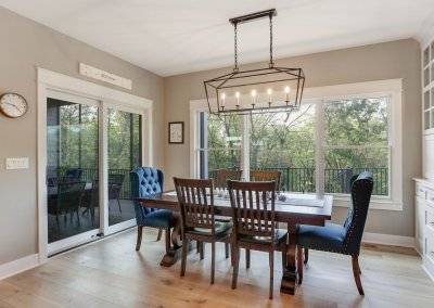 Eat in kitchen area with custom display, large lighting fixture and sliding door to three season porch.