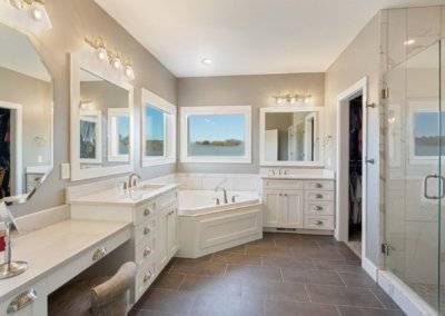 Premier bathroom with shower, tub, dual vanity and heated tile flooring.