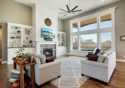 Great room with custom built ins, large window space, fireplace and hardwood flooring.