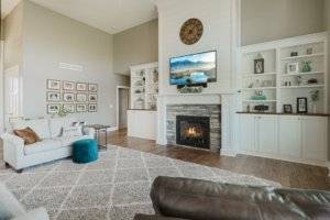 Living room fireplace, white built in cabinetry and hardwood flooring.