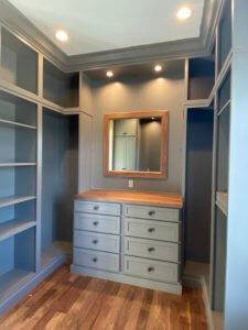 His walk in closet with built in dresser