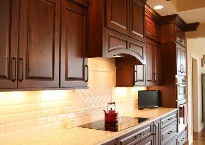 Cream colored kitchen with dark stained cabinetry.