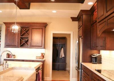Kitchen with dark cabinetry, hardwood floors and ceiling beams.