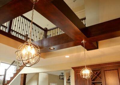 Open two story kitchen with pendant lighting, wood beams and recessed can lighting.