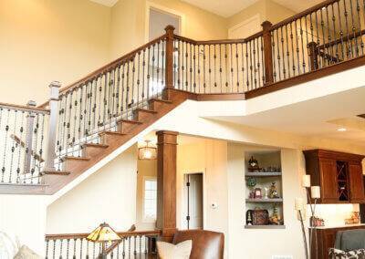 Two story open great room with stair railing and light fixture.