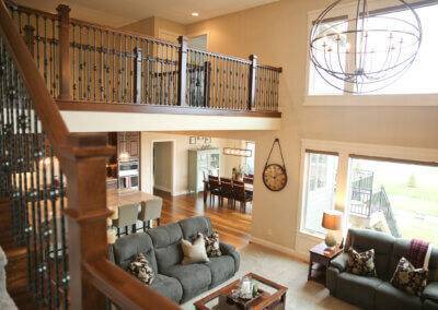 Open two story family room with catwalk, windows, and light fixture.