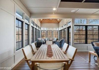 Three season porch with table and sitting area.