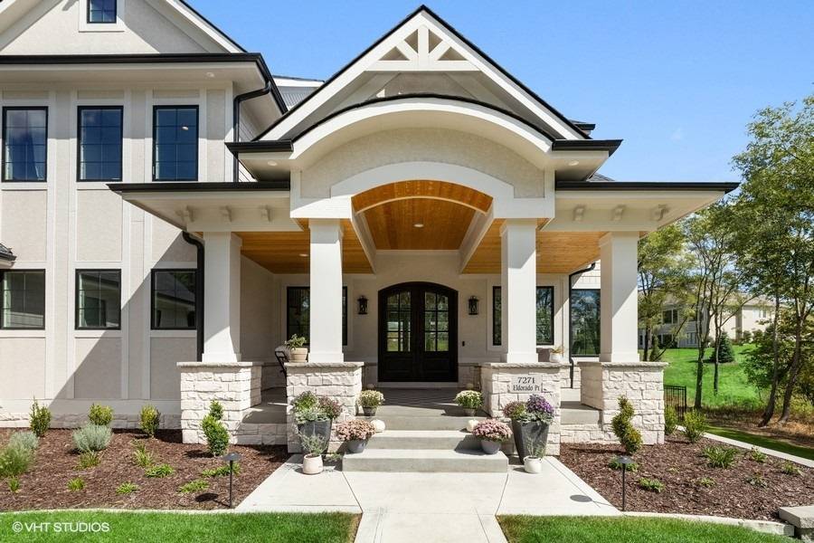 Front porch with stone columns, rounded arches and interesting roofline