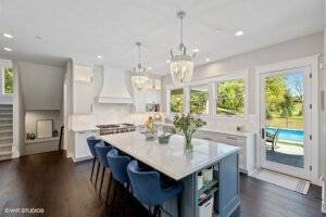 Chef's kitchen with chandelier pendants, walk out to pool and island.