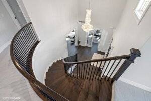 Spiral staircase view, custom build with chandelier in entry.