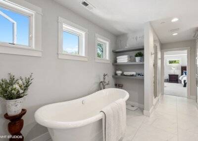 Soaking tub in primary suite, tile floor and custom shelving.